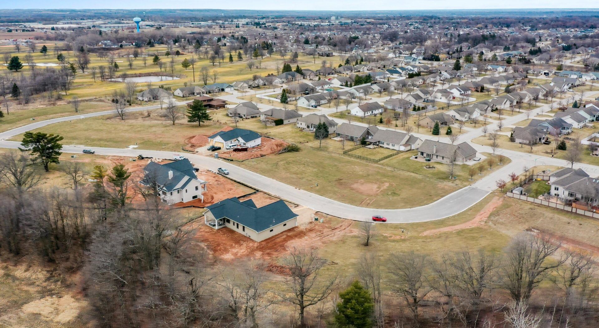 drone image of the subdivision with three houses being built